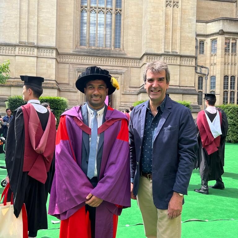 Dr Laxman Sivanathan in his robes with Guy Atkins (MD) outside the Wills memorial building at Bristol University